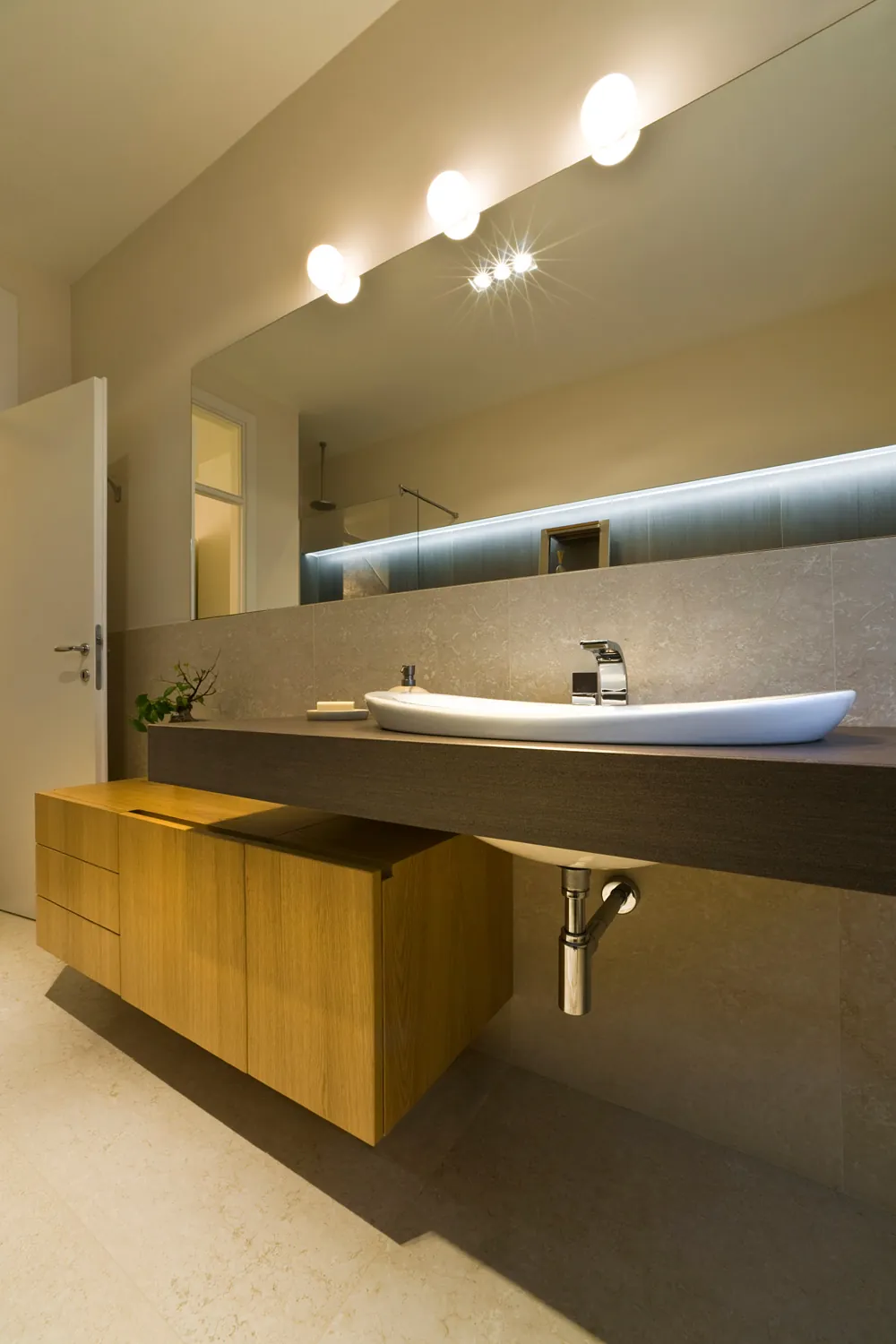 Bagno con mobile sospeso in legno e lavabo in appoggio
