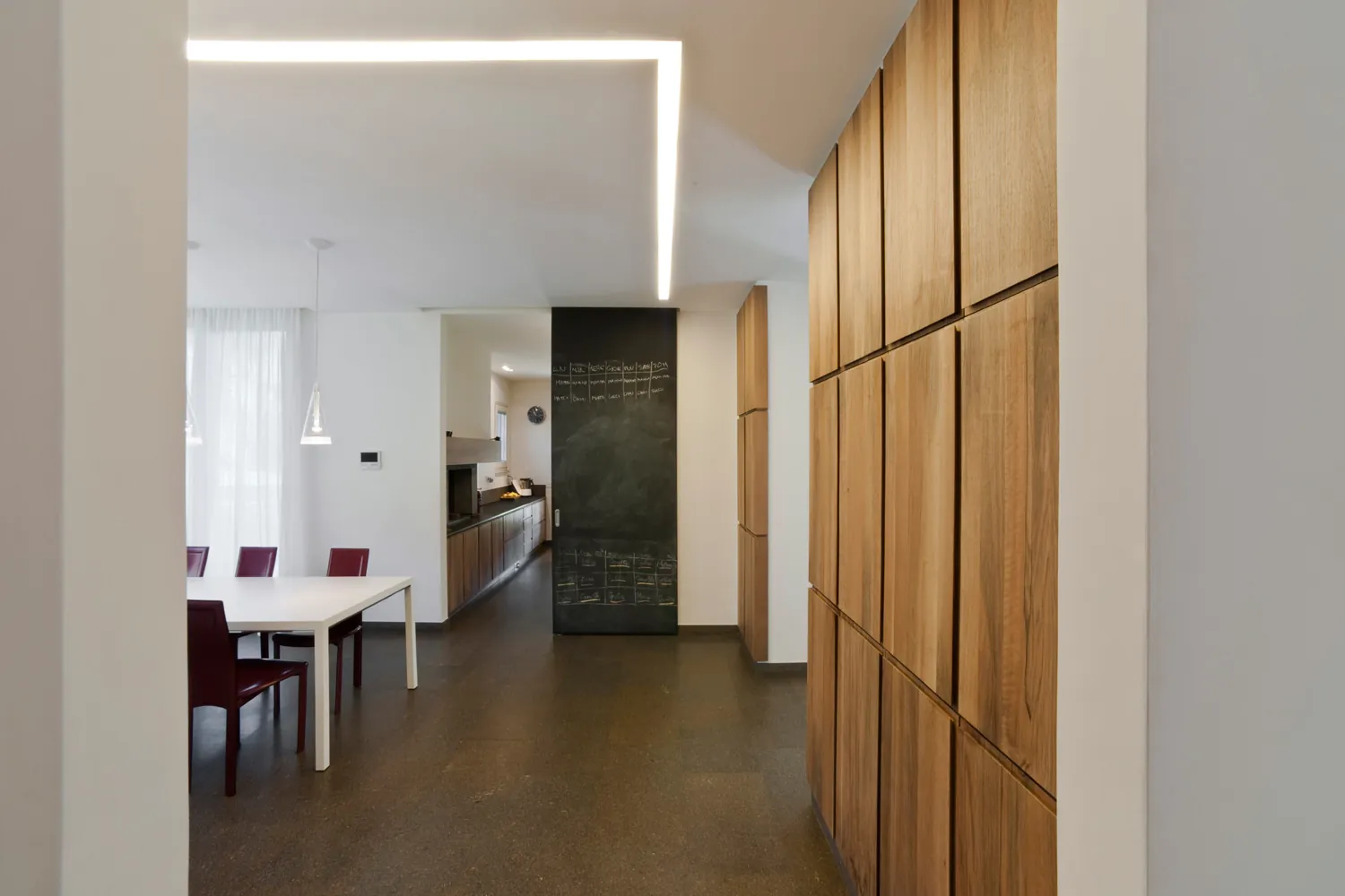 Corridoio con armadi in legno e un taglio di luce nel soffitto