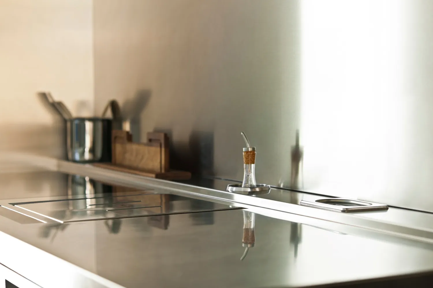 Piano cucina in acciaio con gli utensili, in controluce
