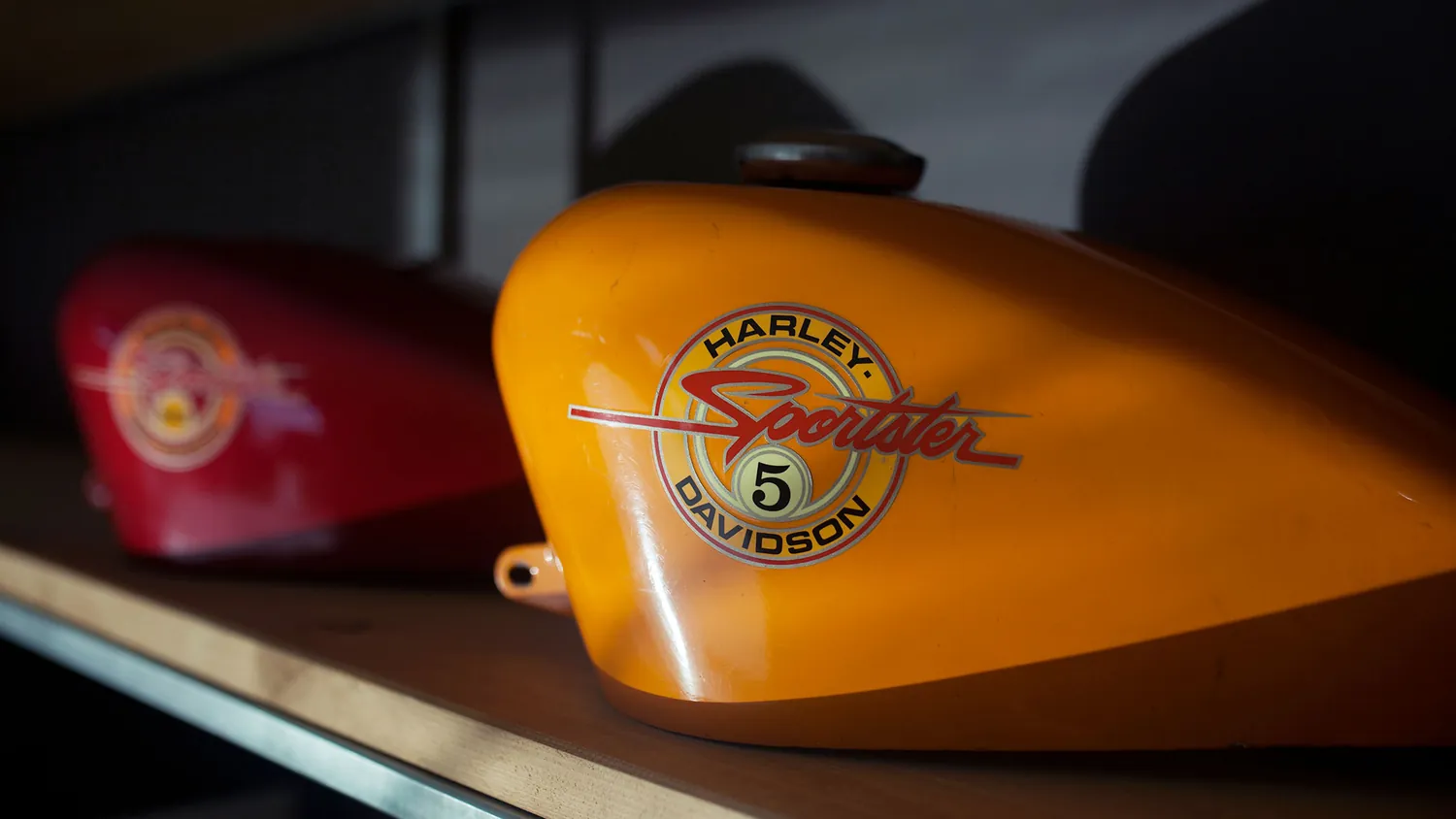Serbatoi di motociclette d’epoca esposti su una mensola