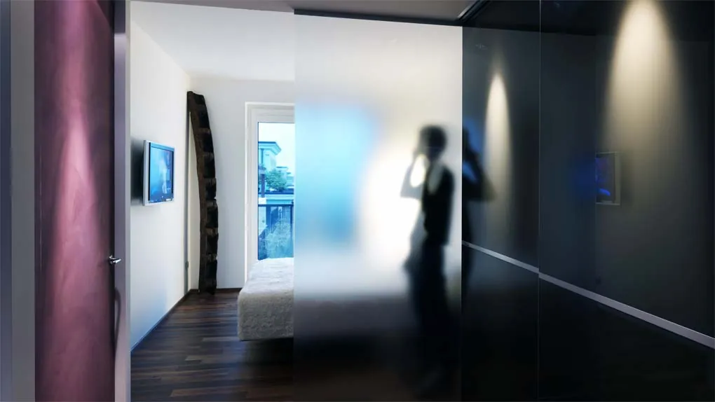 Camera da letto con parete in vetro satinato e una figura in controluce