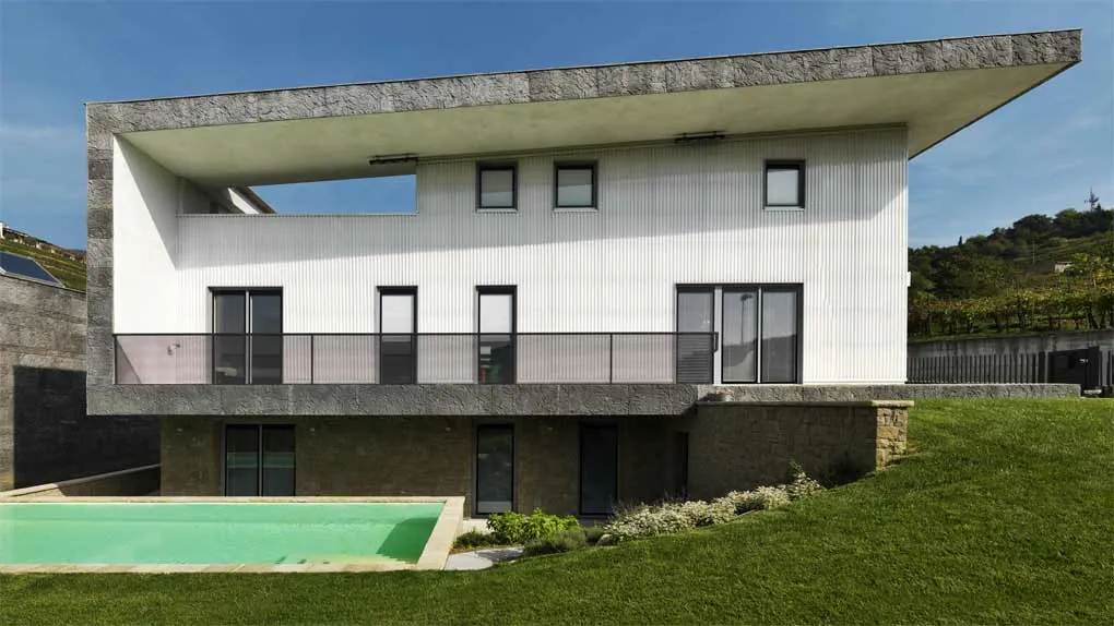 Villa bianca su due livelli con la piscina e il prato in pendio, in Franciacorta